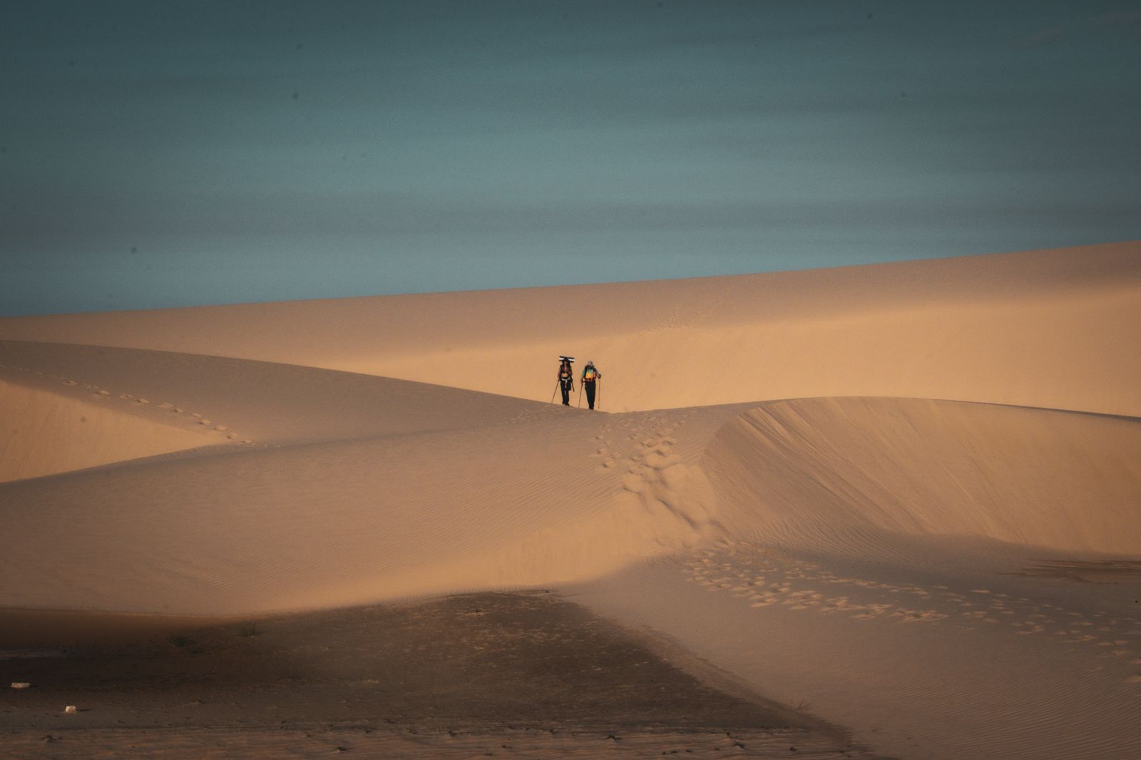 Caminhantes nas dunas ao fim do dia