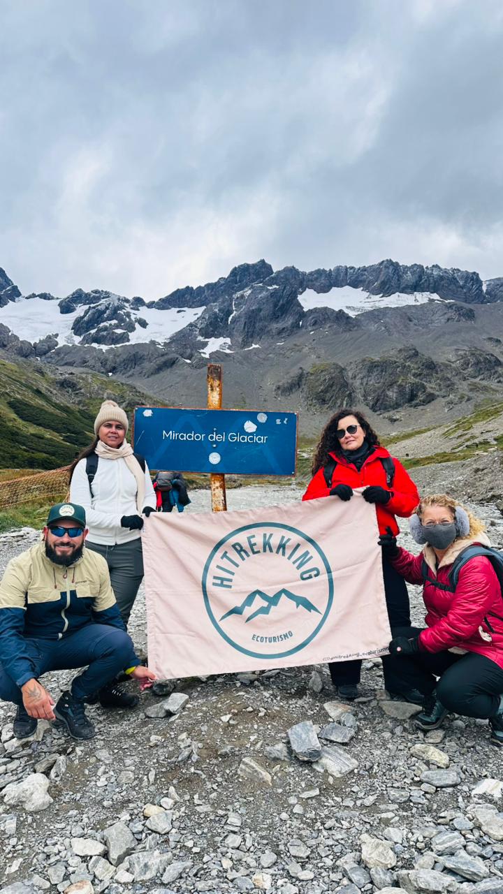 Grupo HiTrekking com sua bandeira no mirante de um glaciar na Patagônia